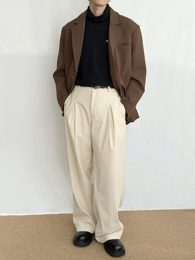 Man in a dark brown blazer with beige trousers