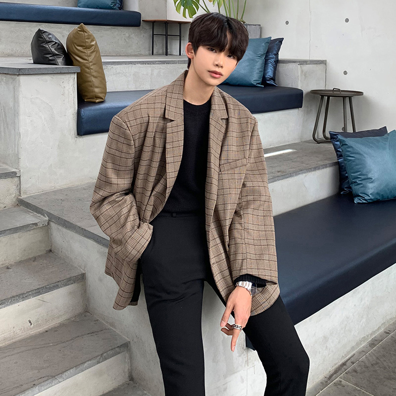 Man in a brown checkered blazer with black trousers