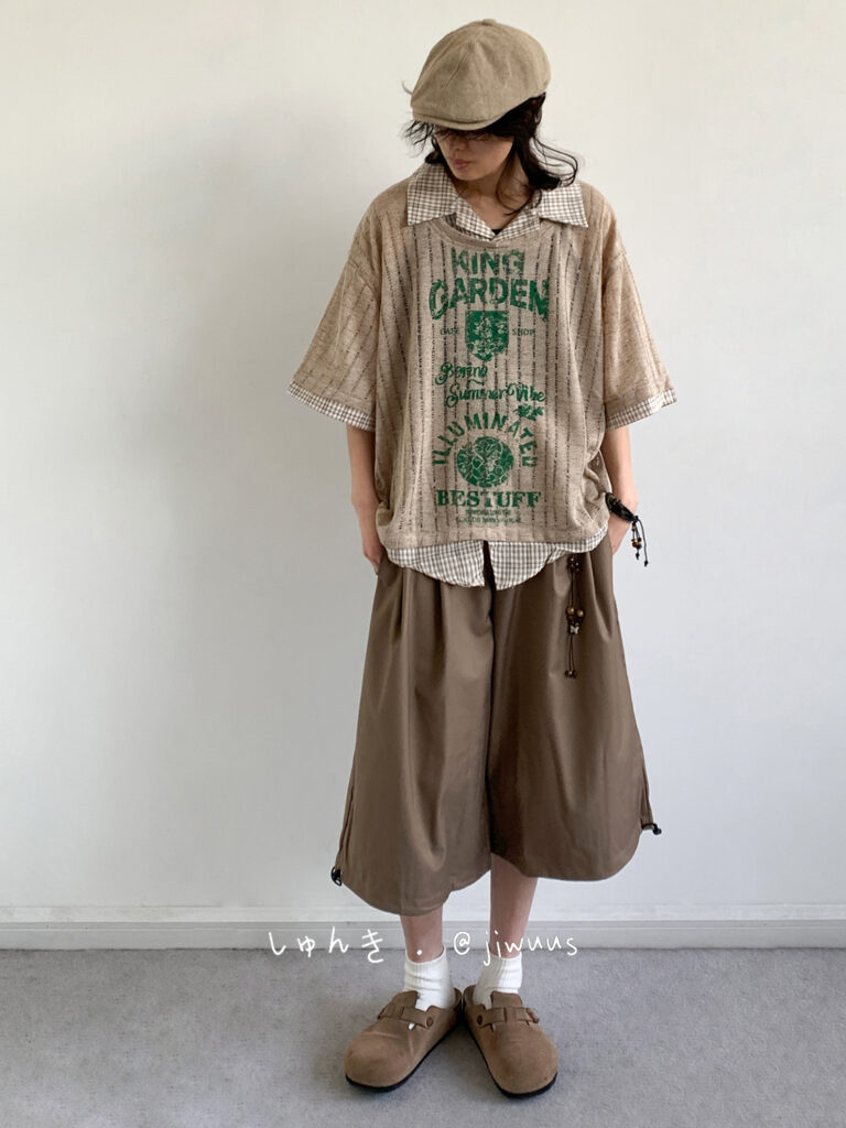 Sandy flat cap + Graphic clay-beige knit + Gingham collar pop + Cocoa culotte shorts + White crew socks + Cork-strap clogs